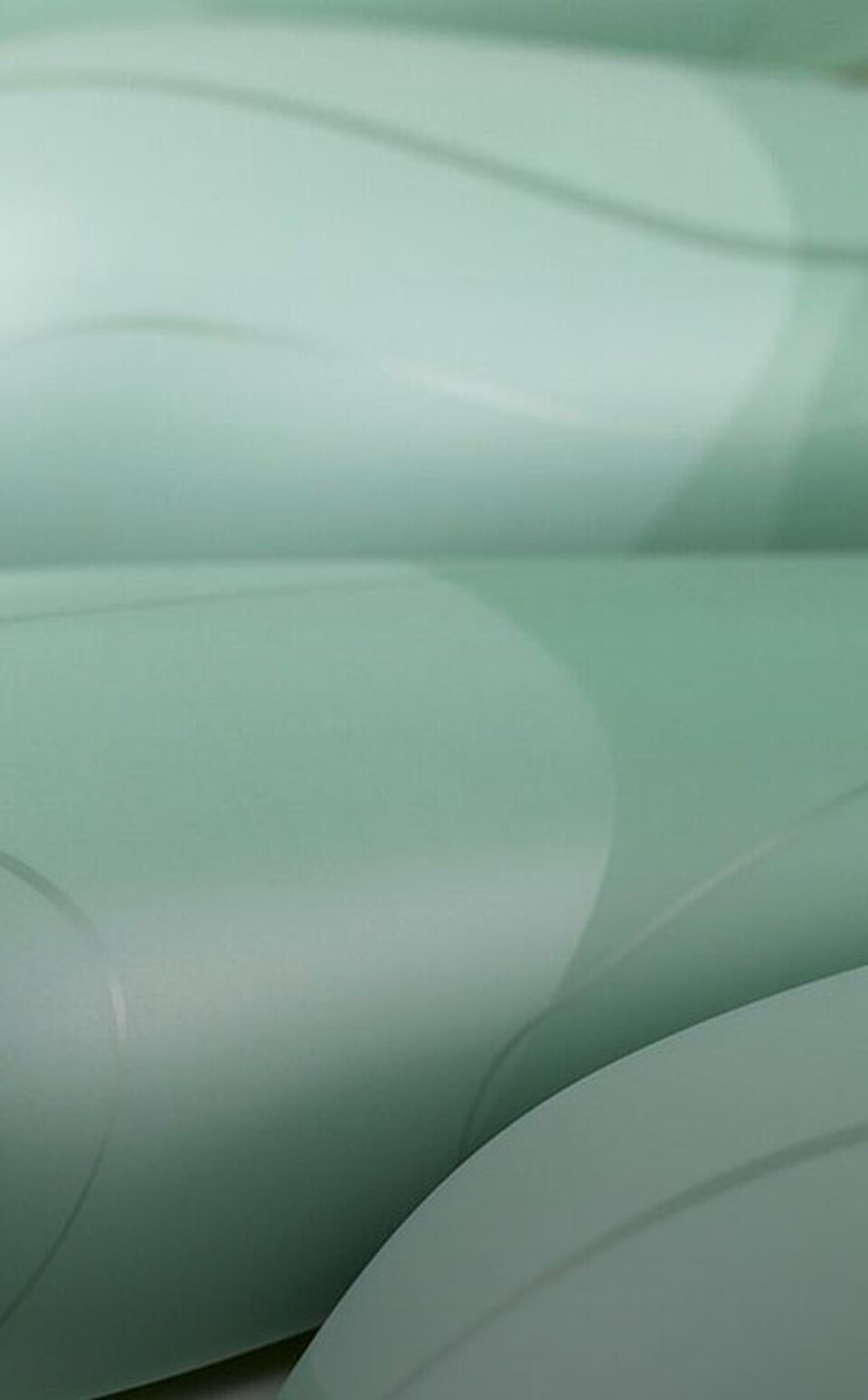 Kunststoffoberfläche in sanften Grüntönen mit fließendem, geometrischem Design und mattem Finish
